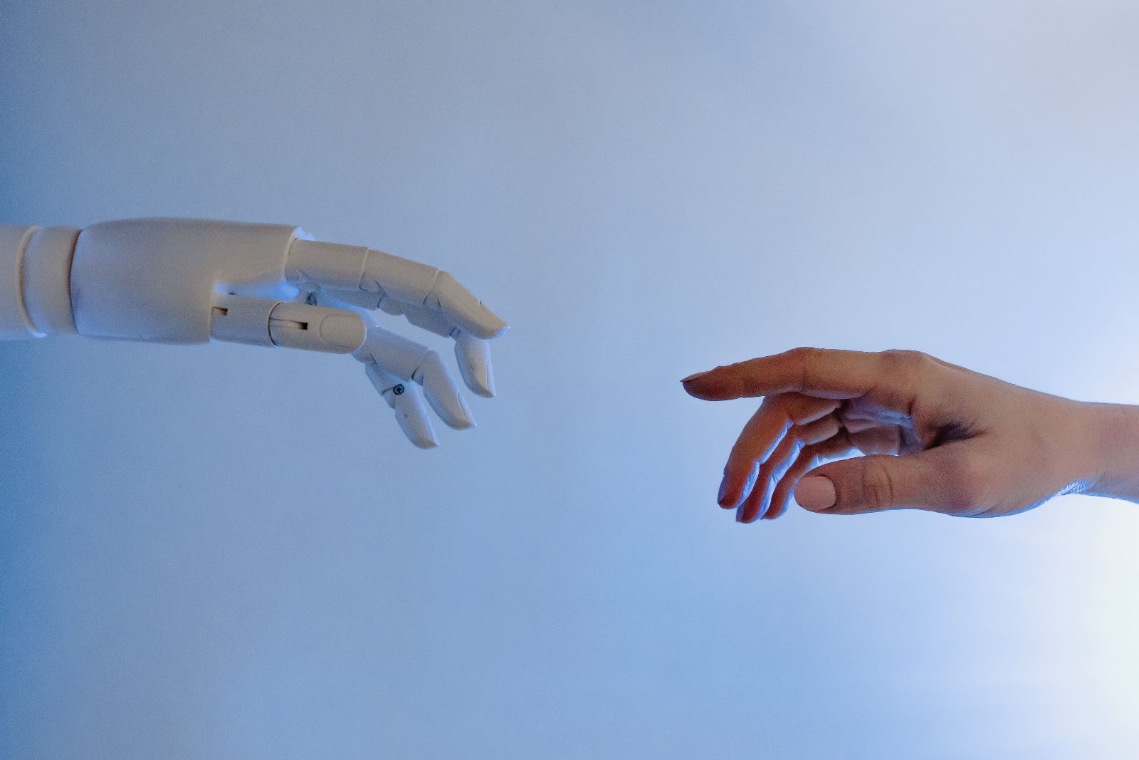 Persona extendiendo la mano hacia un robot, representando la colaboración entre humanos y agentes de IA autónomos