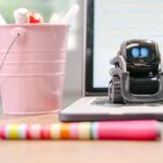 Robot en miniatura sobre teclado de laptop, simbolizando la automatización con IA
