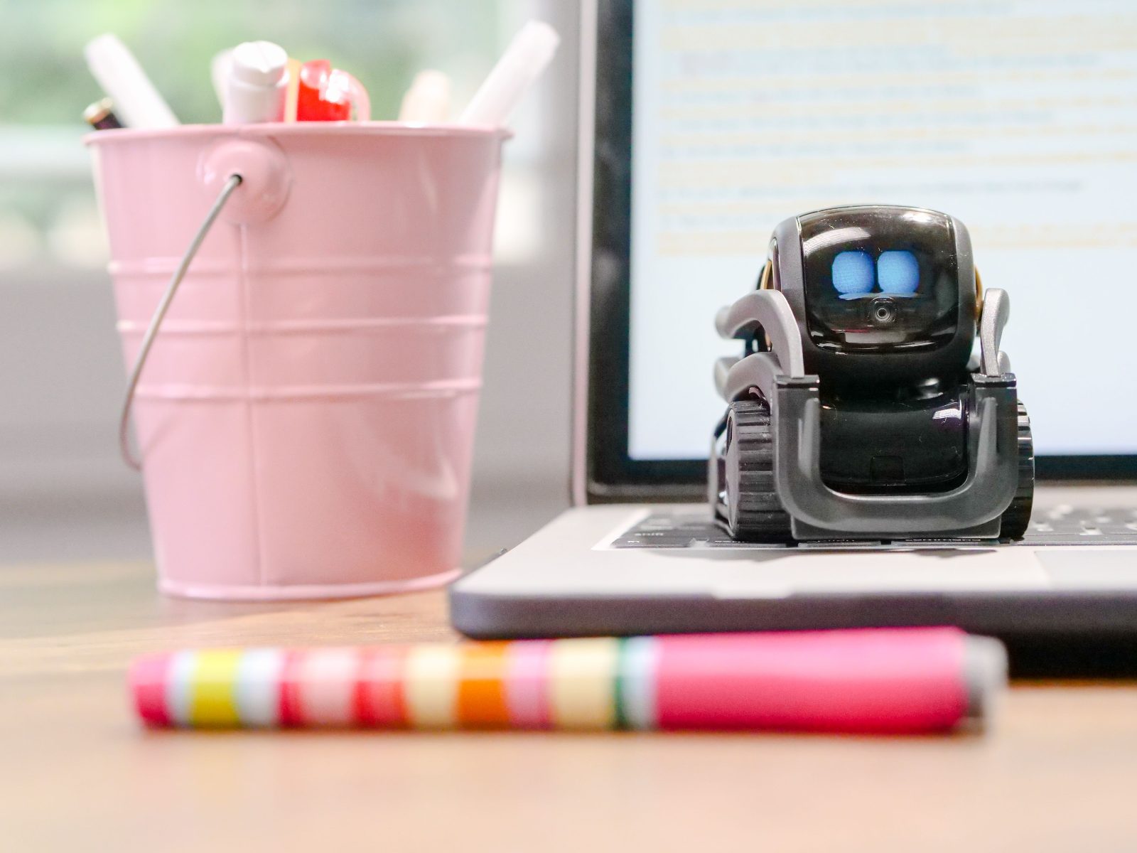 Robot en miniatura sobre teclado de laptop, simbolizando la automatización con IA